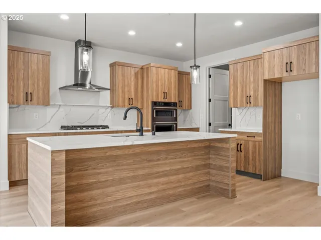 a view of kitchen with kitchen island granite countertop cabinets and refrigerator
