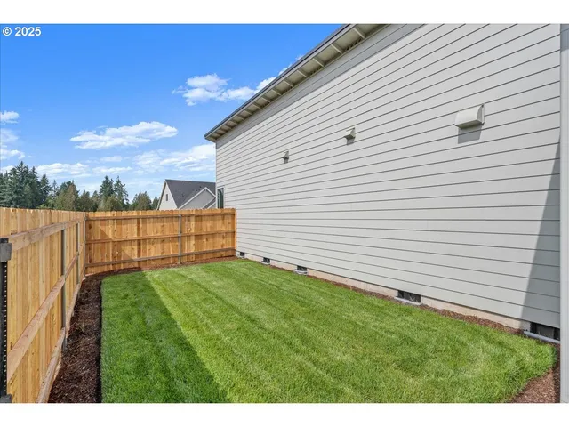 a view of backyard with wooden fence