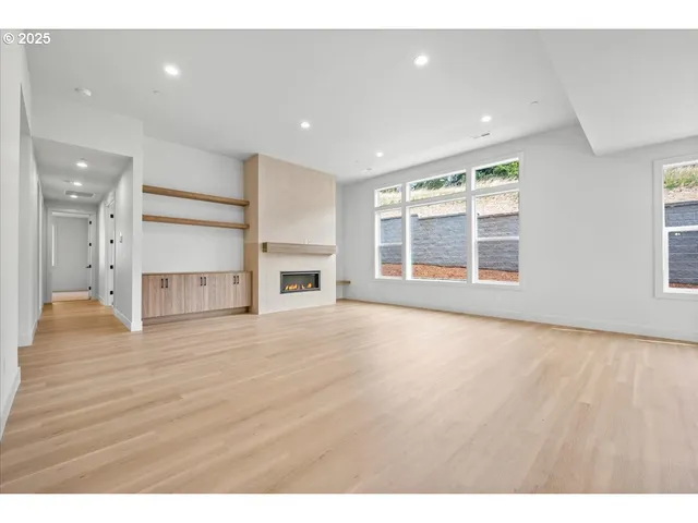 a view of empty room with a fireplace and wooden floor