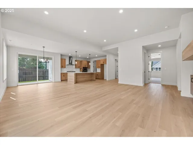 a view of empty room with wooden floor and floor to ceiling window