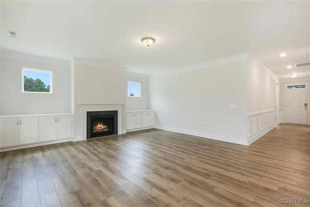 a view of empty room with wooden floor and fireplace