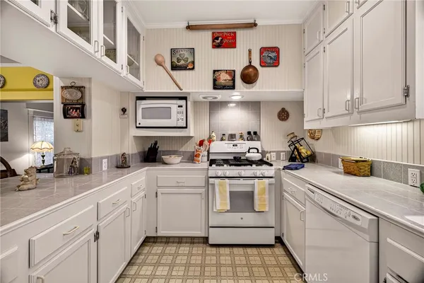a kitchen with white cabinets and white appliances