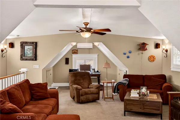 a living room with furniture a ceiling fan and a window