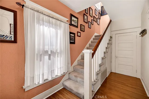 a view of staircase with lots of frames on wall and a window