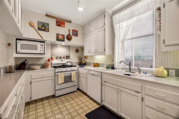 a kitchen with cabinets appliances and a window
