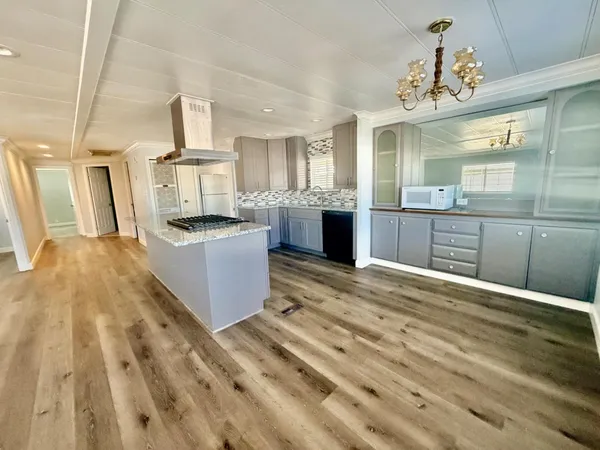 a large kitchen with stainless steel appliances kitchen island granite countertop a sink stove and refrigerator