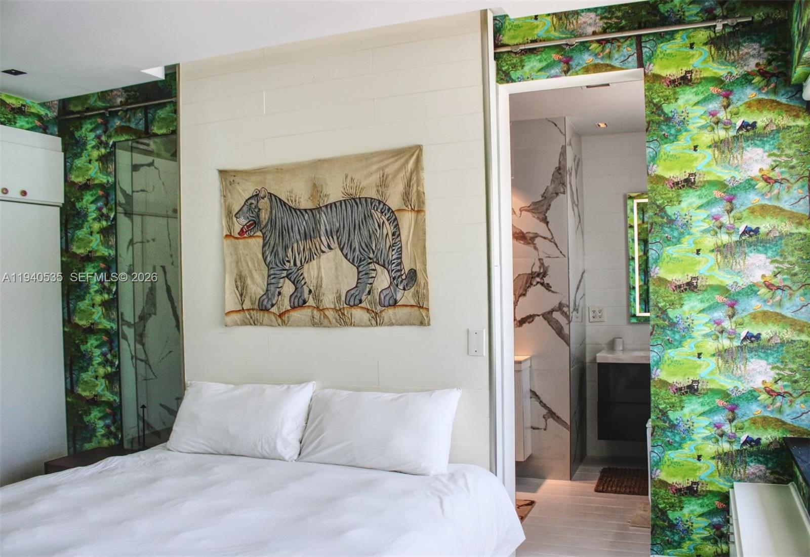 4710 Pine Tree Drive, Unit 49 Miami Beach, FL 33140 - Photo 11 of 26 a bedroom with a bed and a painting on the wall