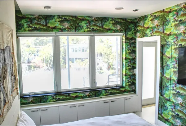 a white painted wall with a painting on the wall