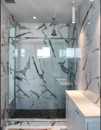 a bathroom with a double vanity sink mirror and shower