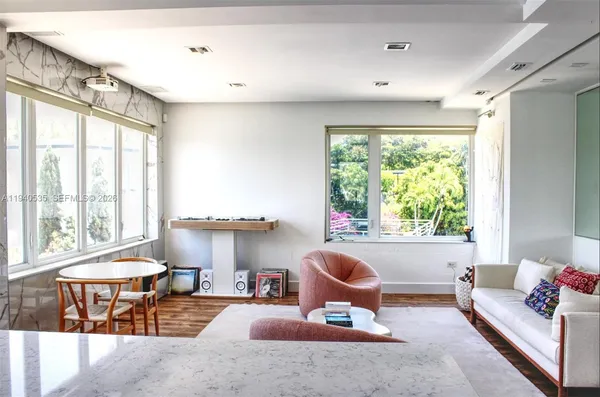 a bedroom with furniture and large windows