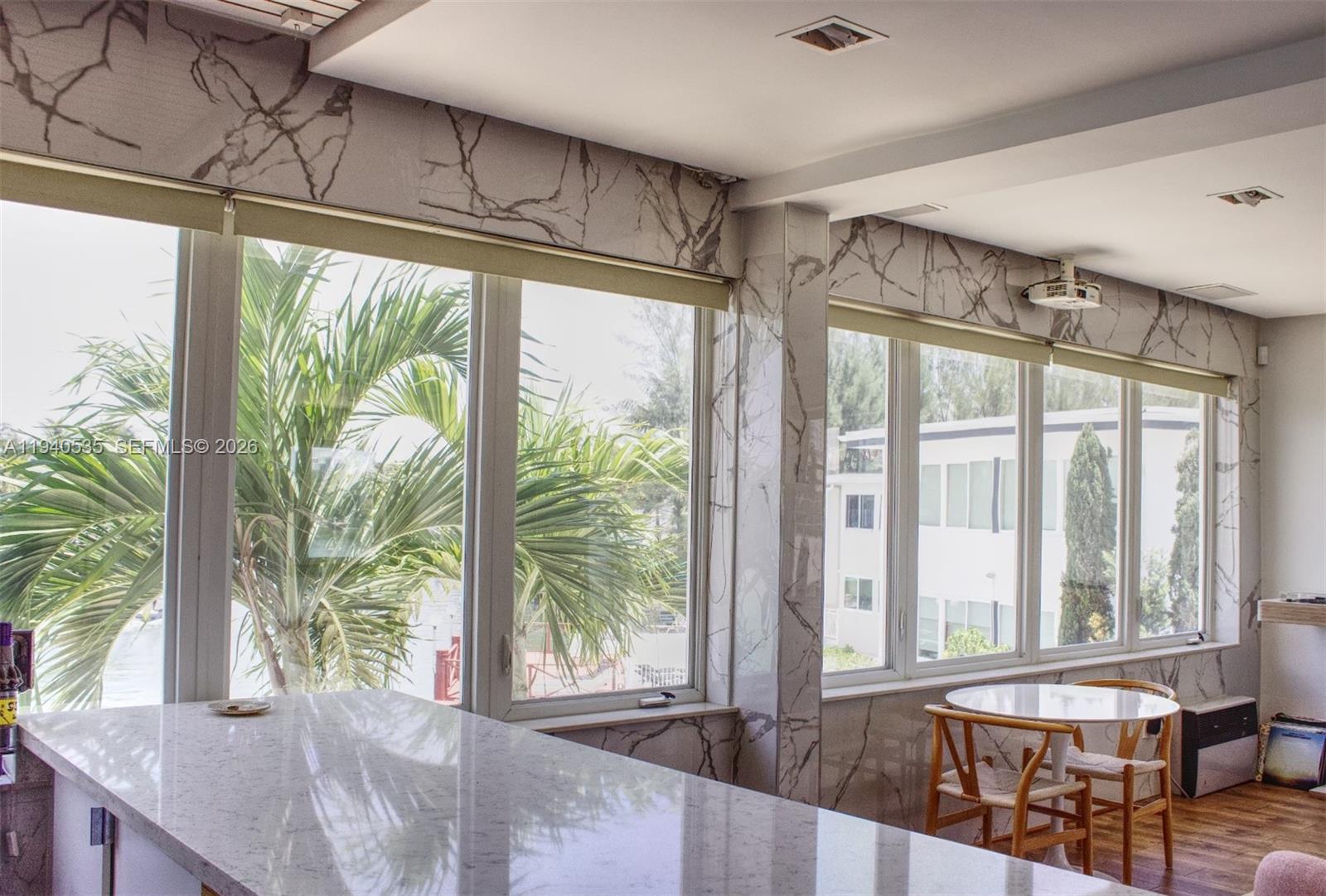 4710 Pine Tree Drive, Unit 49 Miami Beach, FL 33140 - Photo 7 of 26 a bedroom with furniture and large windows