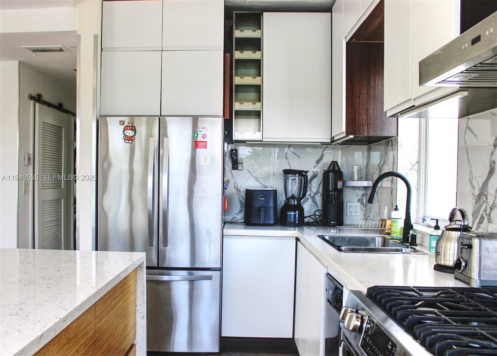 4710 Pine Tree Drive, Unit 49 Miami Beach, FL 33140 - Photo 9 of 26 a kitchen with stainless steel appliances granite countertop a refrigerator and a sink