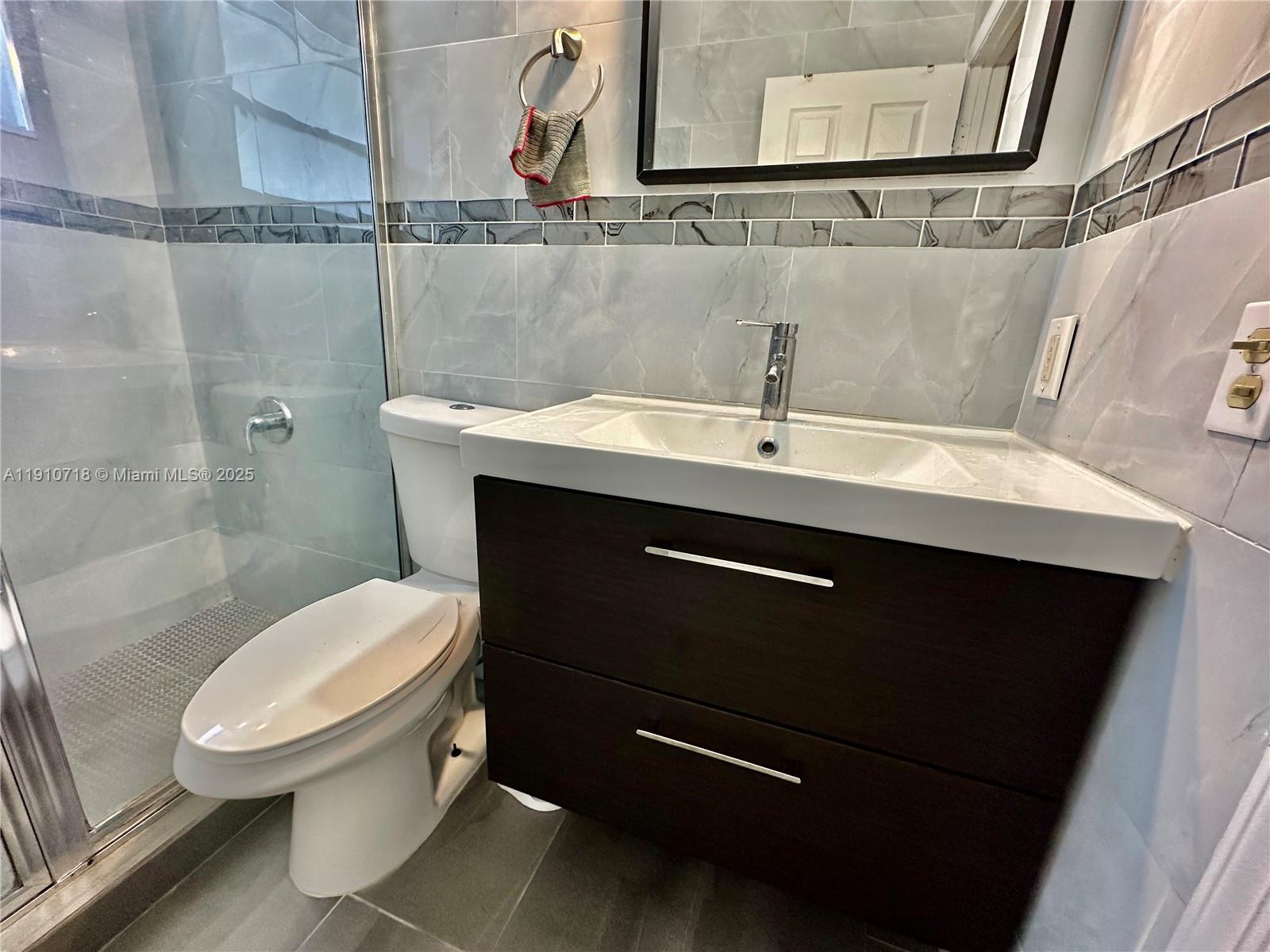 5259 Northwest 184th Lane Miami Gardens, FL 33055 - Photo 16 of 32 a bathroom with a sink mirror vanity and toilet