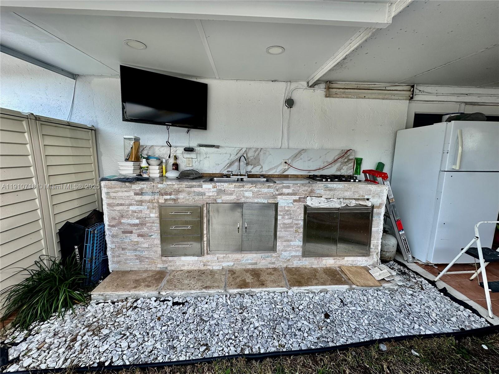 5259 Northwest 184th Lane Miami Gardens, FL 33055 - Photo 20 of 32 a kitchen with a stove a sink and a microwave
