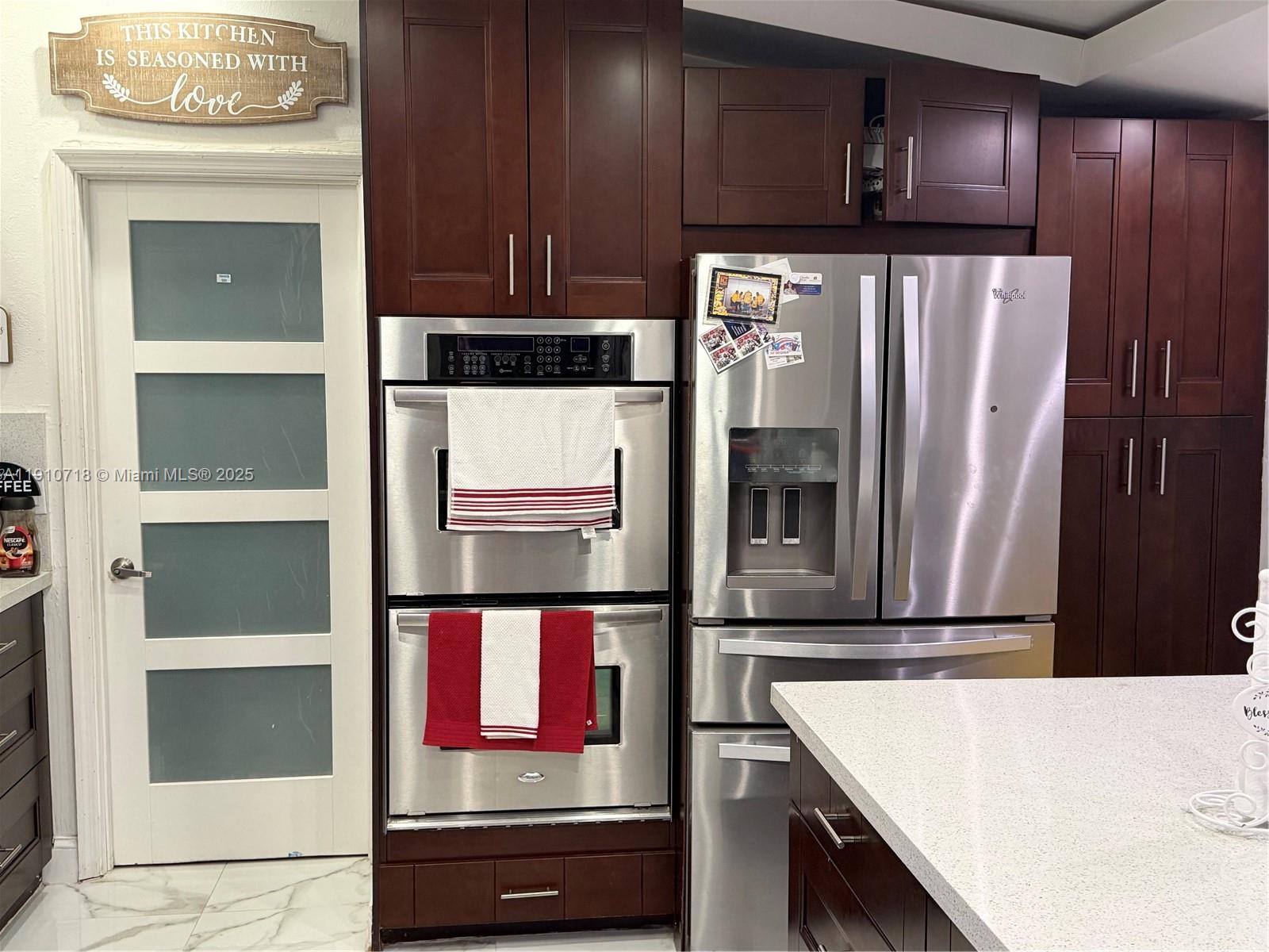 5259 Northwest 184th Lane Miami Gardens, FL 33055 - Photo 26 of 32 a kitchen with stainless steel appliances wooden cabinets and a refrigerator