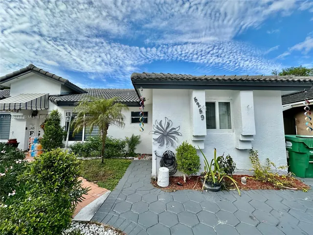 a front view of a house with potted plants