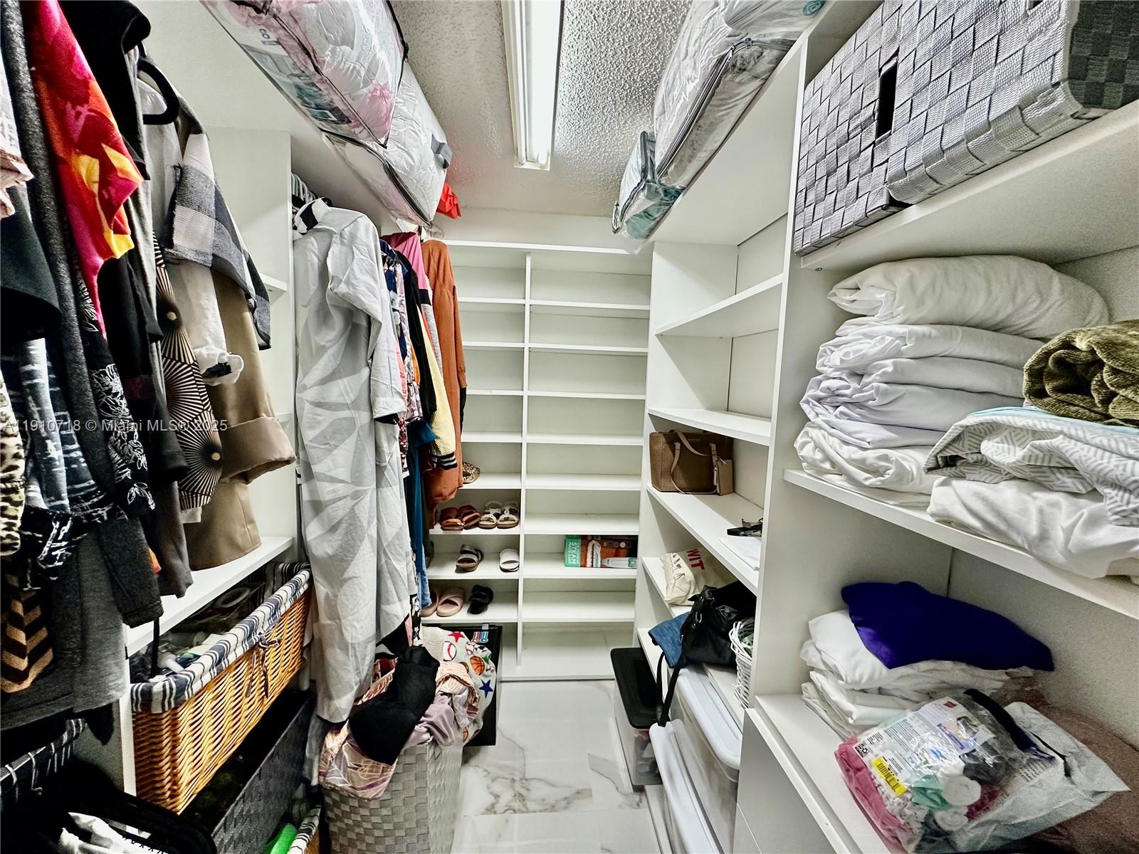 5259 Northwest 184th Lane Miami Gardens, FL 33055 - Photo 8 of 32 a view of walk in closet with clothes and shoes