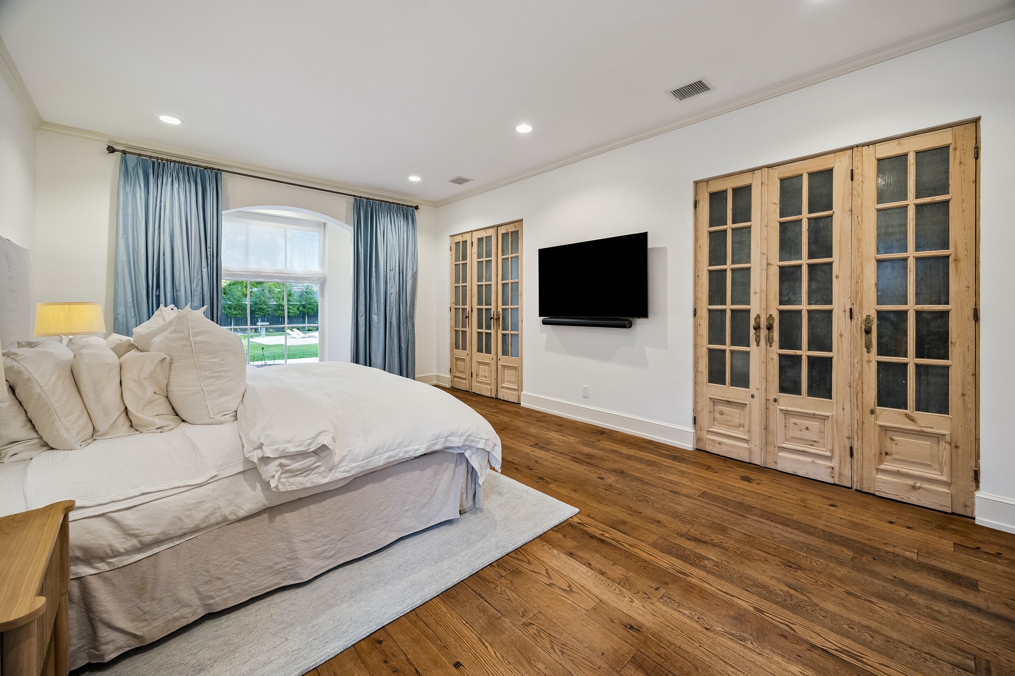 448 Blalock Road Houston, TX 77024 - Photo 23 of 49 a spacious bedroom with a bed and a flat screen tv