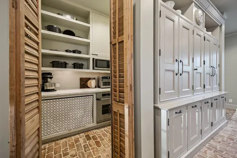 a dining hall with stainless steel appliances kitchen island granite countertop furniture and a chandelier