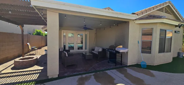 a view of a patio with table and chairs potted plants and floor to ceiling window
