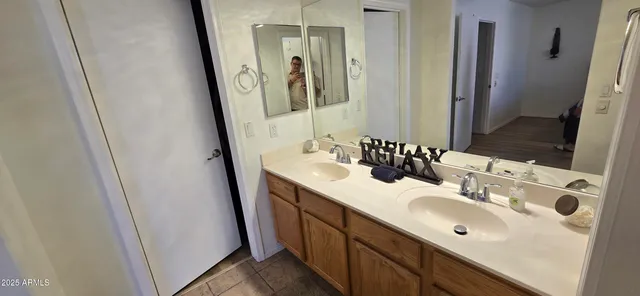 a bathroom with a double vanity sink and a mirror
