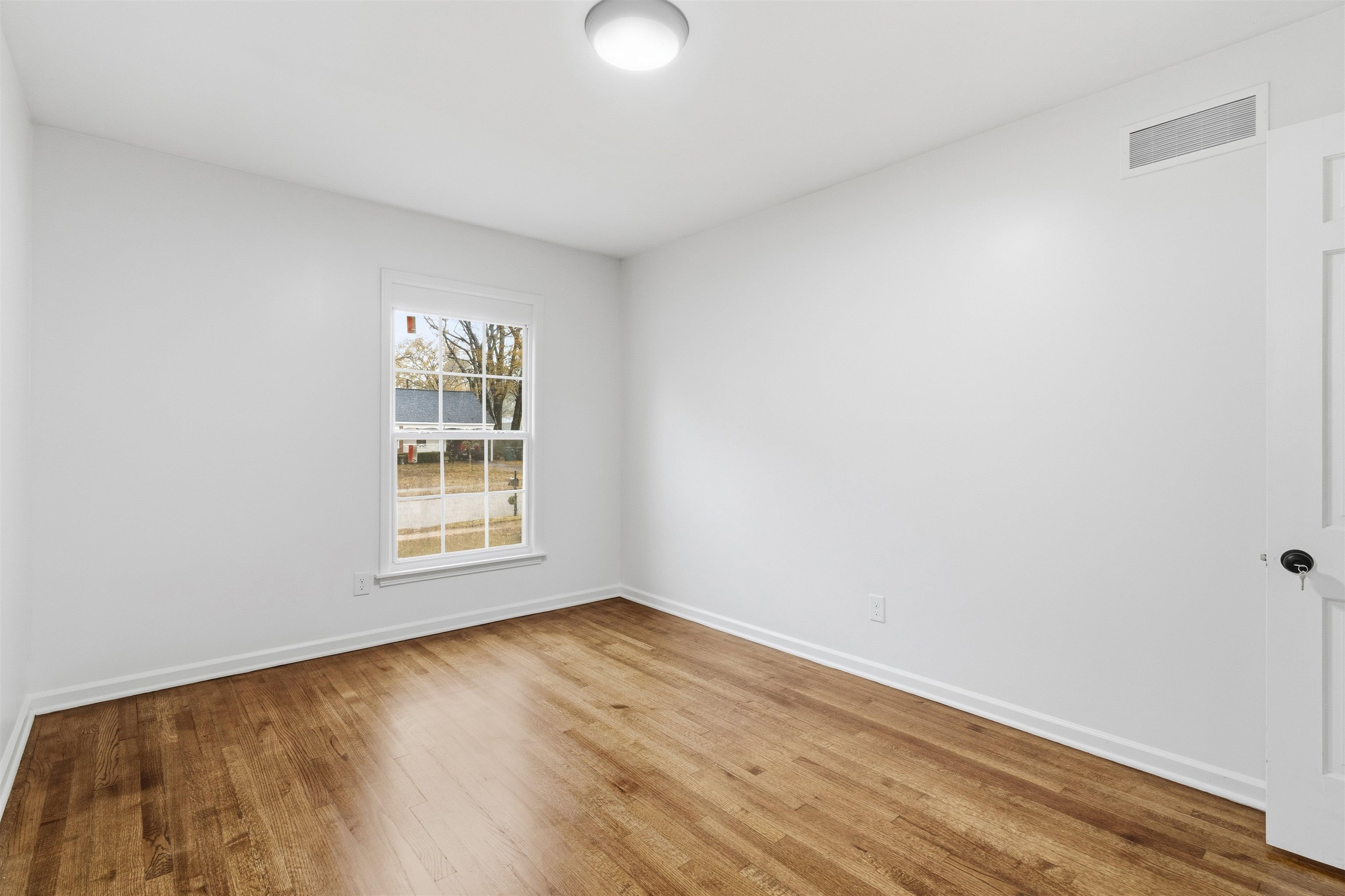 416 Rosser Road Memphis, TN 38120 - Photo 20 of 30 an empty room with wooden floor and windows