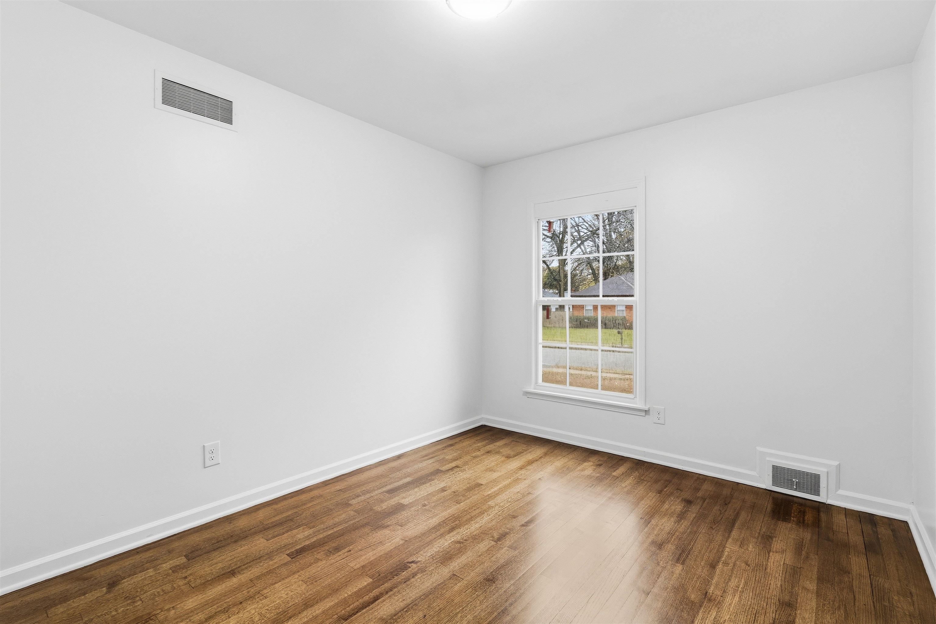 416 Rosser Road Memphis, TN 38120 - Photo 22 of 30 an empty room with wooden floor and windows