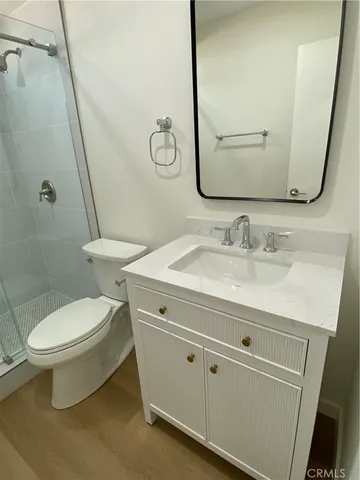 a bathroom with a granite countertop toilet sink and mirror