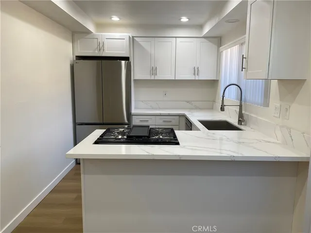 a kitchen with a sink a refrigerator and cabinets