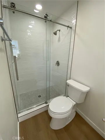 a white toilet sitting next to a shower