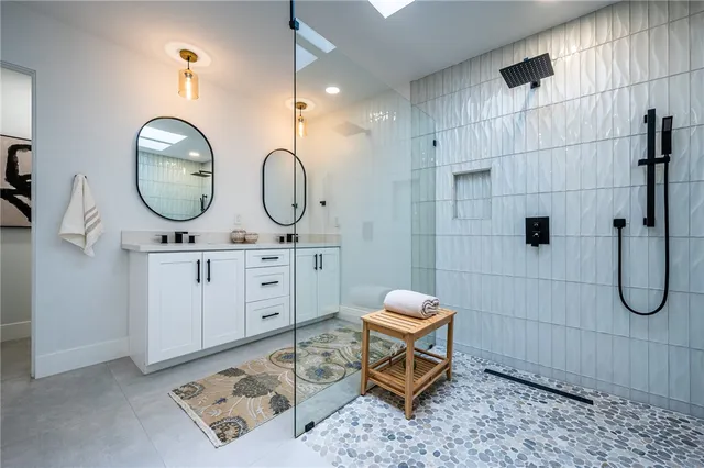 a bathroom with a toilet a sink a mirror and shower