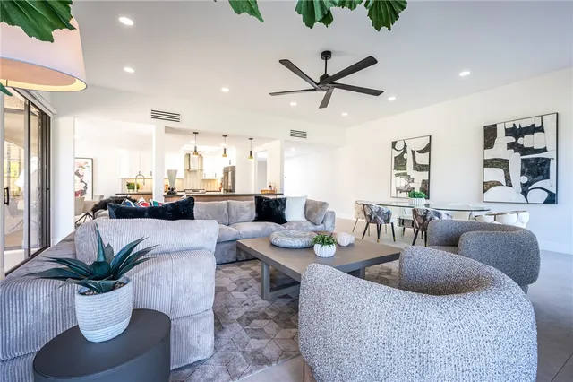 a living room with furniture kitchen view and a potted plant
