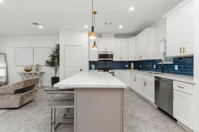 a kitchen with stainless steel appliances kitchen island granite countertop a sink and cabinets