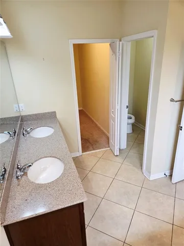 a white toilet sitting next to a white wall