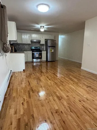 a view of a kitchen with cabinets and wooden floor