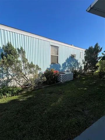 a view of a backyard with lawn chairs plants and fire pit