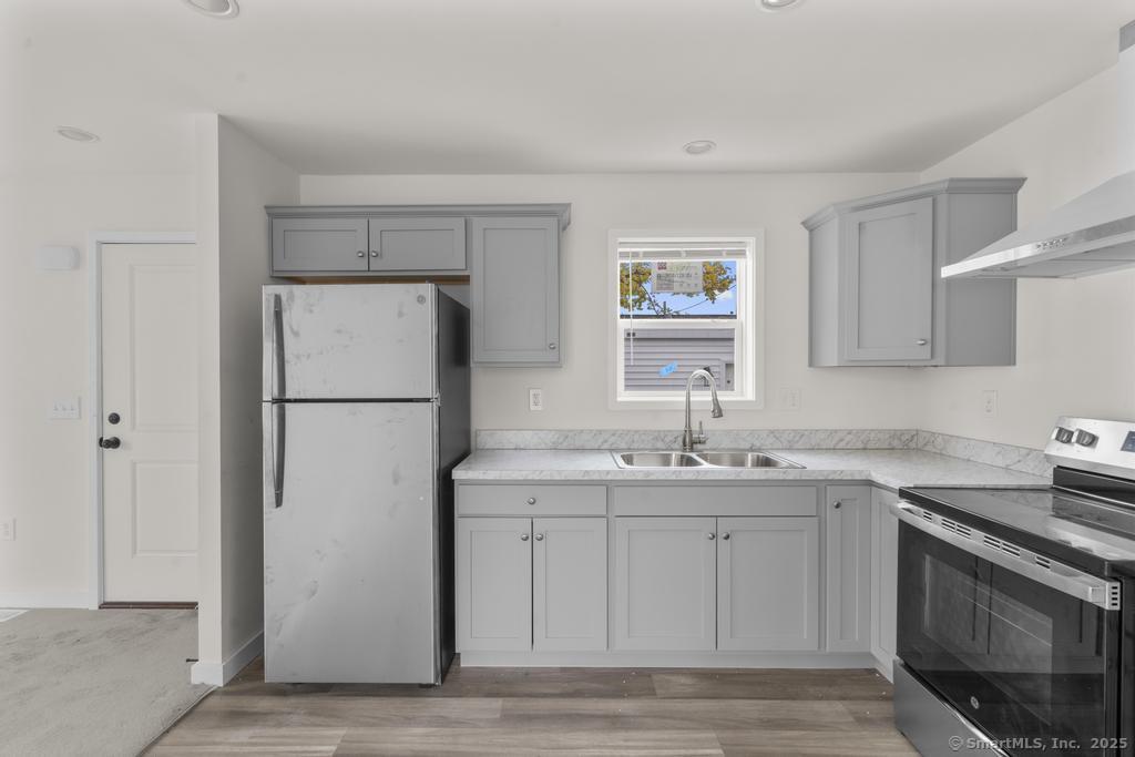 55 Sugar Street, Unit 10 Newtown, CT 06470 - Photo 3 of 18 a kitchen with a sink a refrigerator and a stove