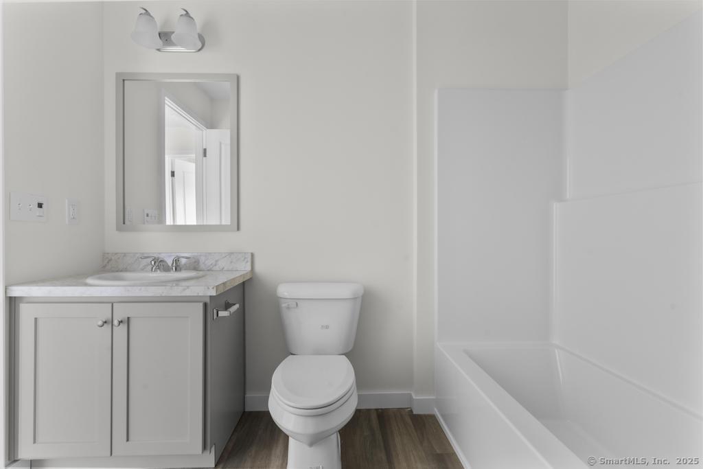 55 Sugar Street, Unit 10 Newtown, CT 06470 - Photo 10 of 18 a bathroom with a toilet a sink and mirror