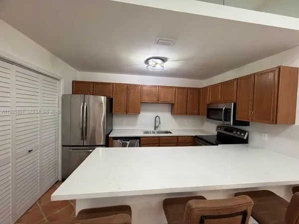 a kitchen with stainless steel appliances a refrigerator and a stove top oven