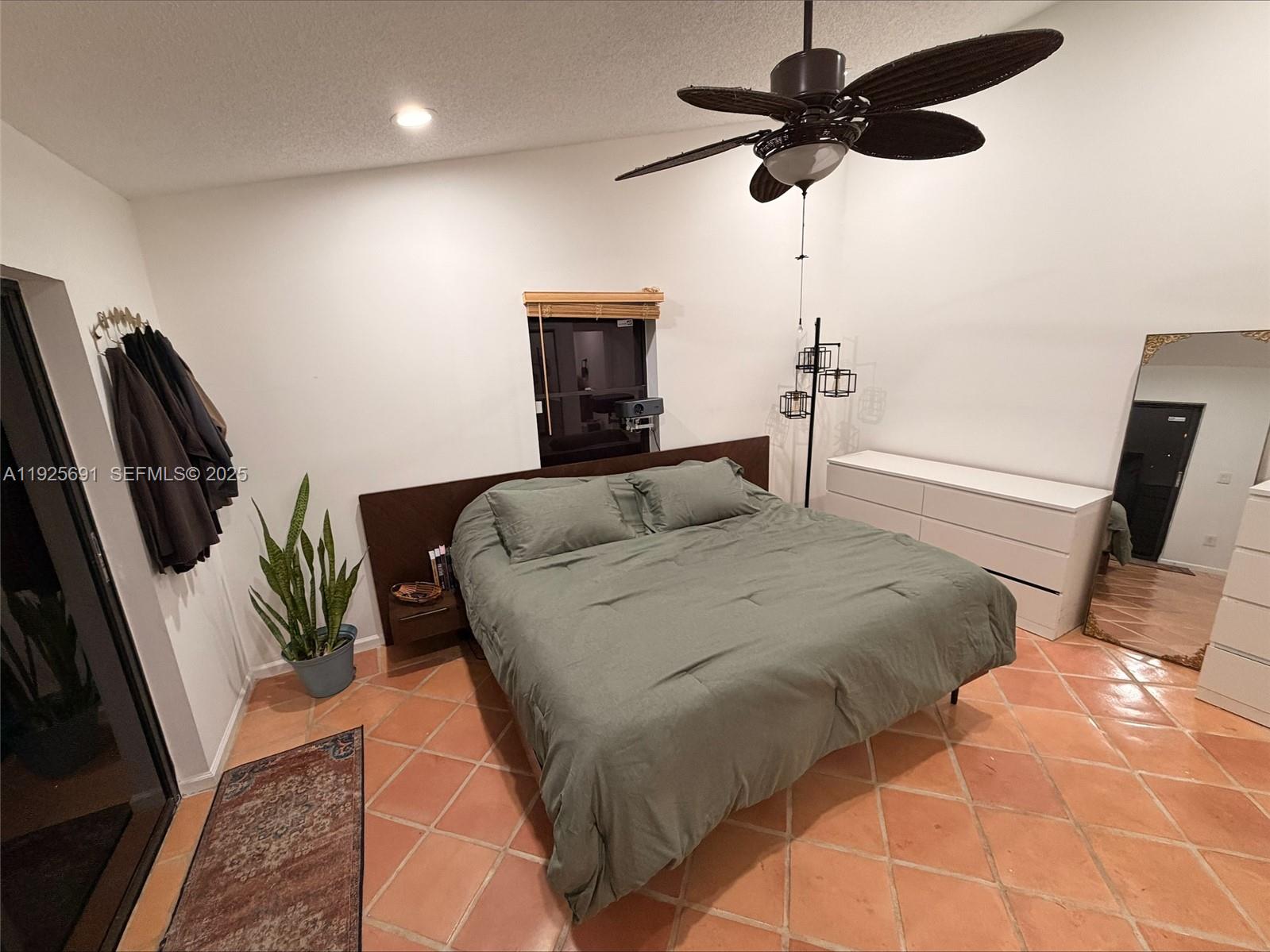 13680 Yarmouth Court, Unit C Wellington, FL 33414 - Photo 9 of 21 a bedroom with bed and a chandelier