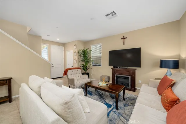 a living room with furniture and a dining table with wooden floor