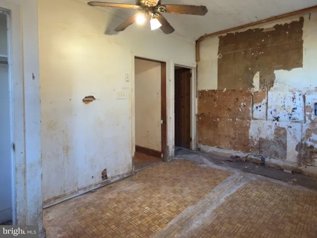 a view of a hallway with wooden floor and a living room