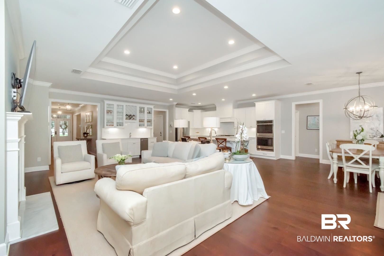 319 Springhill Woods Drive Mobile, AL 36608 - Photo 12 of 39 Living room with a raised ceiling, ornamental molding, a chandelier, dark wood-style flooring, and recessed lighting