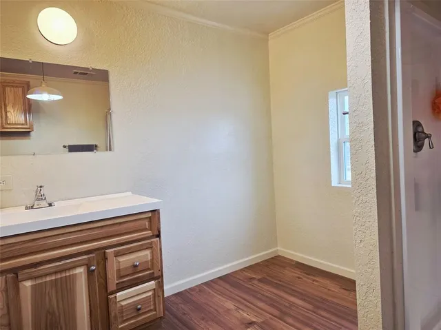 a view of a sink a mirror and wooden floor