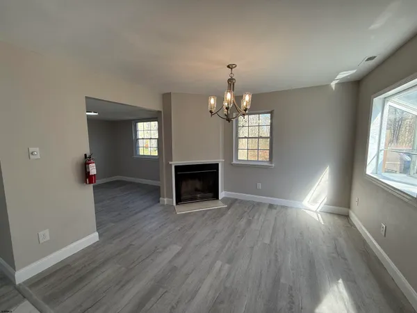 a view of a livingroom with wooden floor fireplace and window