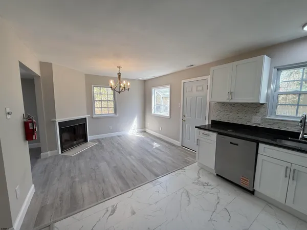 a kitchen with granite countertop a stove a sink and a microwave