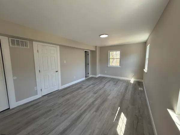 an empty room with wooden floor and window