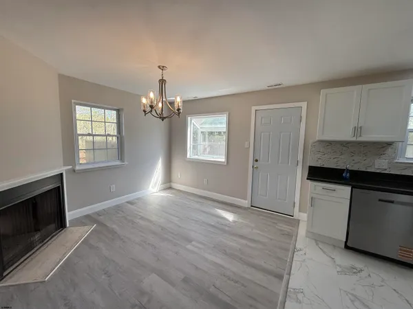 a kitchen with granite countertop white cabinets and window