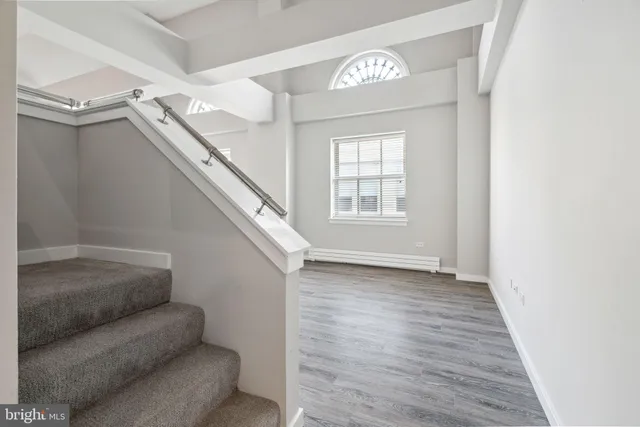 a view of entryway and hall with wooden floor