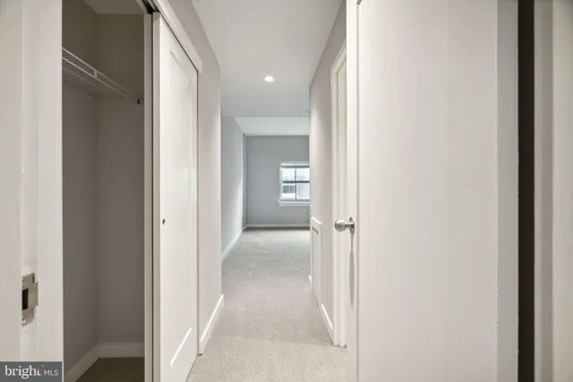 a view of a hallway with wooden floor and closet